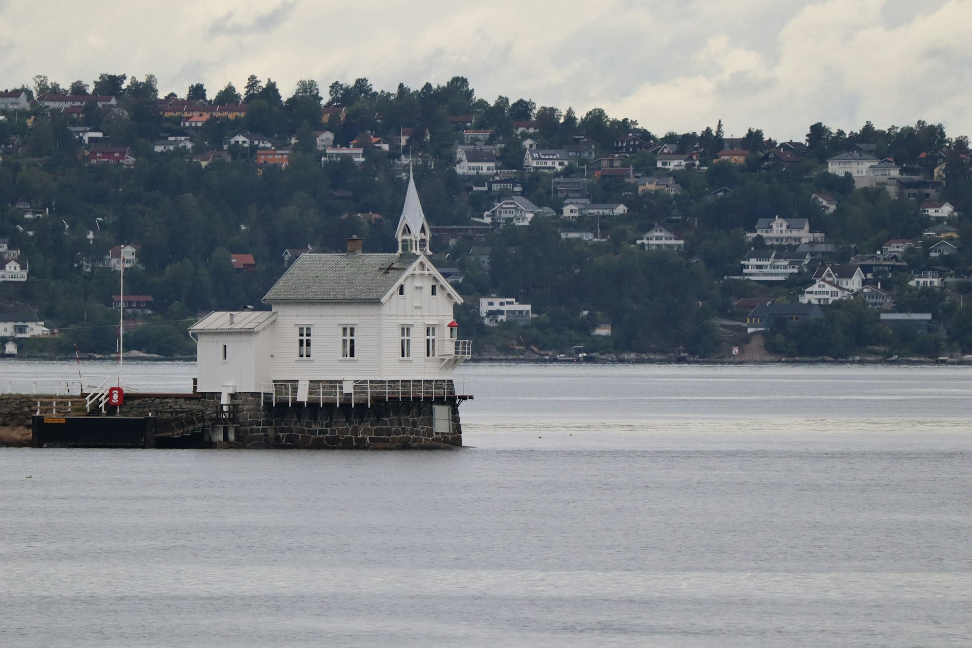 A small white building sitting on top of a body of water